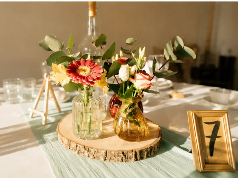 Centre de table de mariage avec fleurs et numéro de table sur rondin de bois lors d'une réception à Nantes