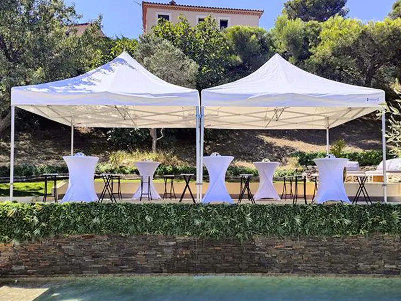Deux barnums blancs Pack Event installés devant une piscine avec mange-debout pour une réception estivale