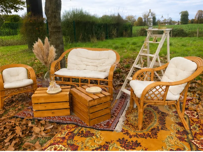 Salon de mariage en rotin avec tapis berbère et pampas pour une réception bohème en extérieur près de Nantes
